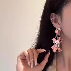 Detailansicht von eleganten rosa Pailletten-Blumen-Quastenohrringen an einem Model