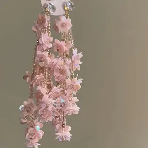 Detaillierte Makroansicht eleganter rosa 3D-Blumen-Quastenohrringe mit funkelnden Zirkonia-Steinen