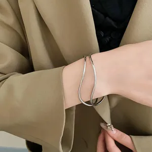 Dettaglio ravvicinato di un bracciale rigido aperto ondulato multistrato argento