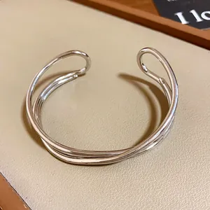 Primo piano di un bracciale a polsino aperto incrociato multistrato in argento