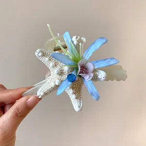 Exquisite ocean-inspired starfish and blue fabric flower hair clip with a sparkling blue rhinestone