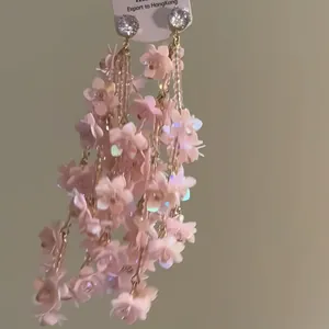 Nahaufnahme von eleganten rosa Pailletten-Blumen-Quastenohrringen mit Zirkon-Steckern