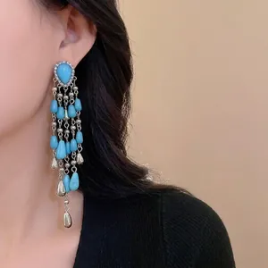 Elegant turquoise water drop tassel earrings on model with ethnic bohemian style flair