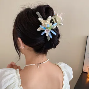 Detailed view of starfish and flower hair claw clip on a woman's elegant bun hairstyle