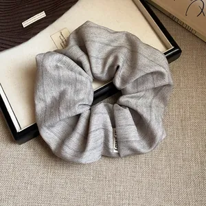 Gros plan d'un chouchou en tissu gris à rayures avec motif à chevrons élégant