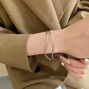 Dettaglio di un bracciale rigido aperto multistrato ondulato argento minimalista