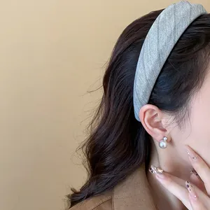 Gros plan d'un serre-tête en tissu rayé gris porté pour un look tendance et chic.