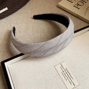 Gros plan d'un serre-tête en tissu à chevrons gris avec un design élégant à dessus haut