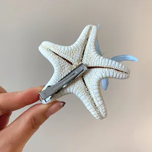 Detail view of starfish hair clip featuring floral accents and a secure metal clip mechanism.