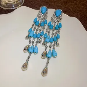 Detailed view of Bohemian turquoise water drop tassel earrings with silver accents.