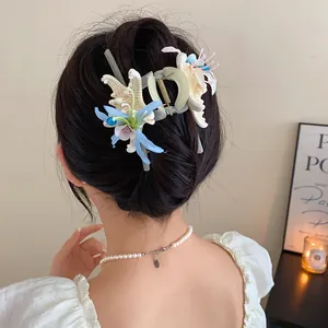 Detailed view of a starfish flower hair claw clip worn on a woman's bun, elegant hair accessory.