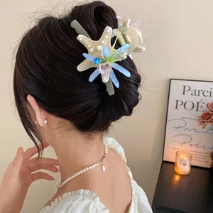 Exquisite beach style starfish and blue flower hair claw clip shown on model hair