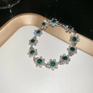 Macro view of French vintage floral bracelet with green gems and white diamonds