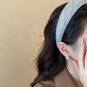 Détail d'un bandeau en tissu à chevrons gris élégant porté par un mannequin asiatique.