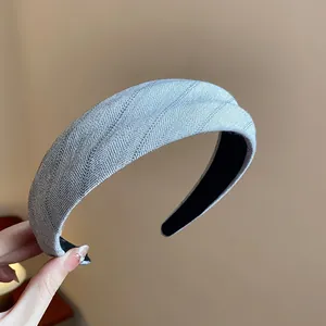 Détail macro d'un serre-tête en tissu rayé gris montrant le style et la texture