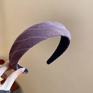 Vue détaillée d'un élégant serre-tête en tissu rayé violet avec un design rembourré