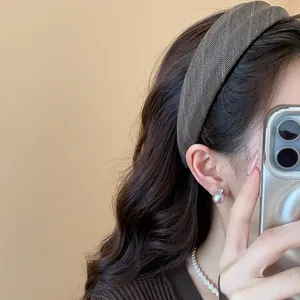 Gros plan d'un serre-tête en tissu rayé marron porté par une femme, style chic coréen