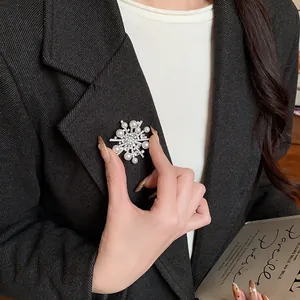 Elegante Schneeflocken-Brosche mit Perlen und Zirkonia am schwarzen Revers