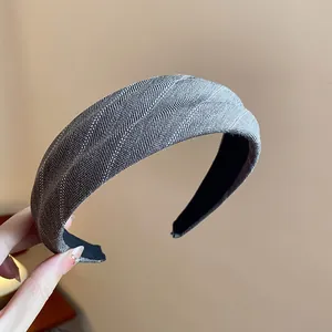 Détail d'un serre-tête en tissu gris à chevrons avec un nœud pour un effet volumisant