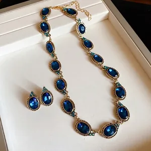 Elegant vintage court style jewelry set featuring blue oval stones in a gold-tone finish