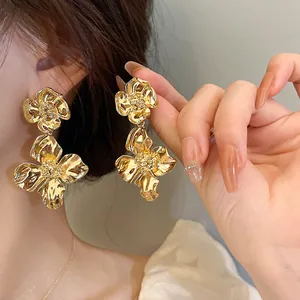 Detailed close-up showing the metallic texture of gold vintage flower drop earrings