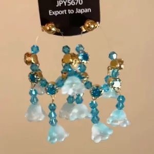 Close-up detail of ethnic style blue crystal bead tassel earrings with flower pendants