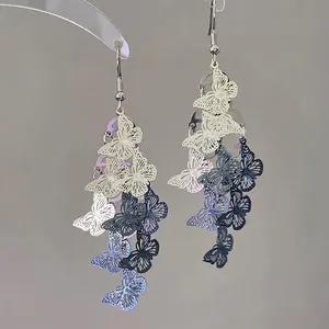 Detail view of multi-colored hollow butterfly charms on elegant tassel earrings