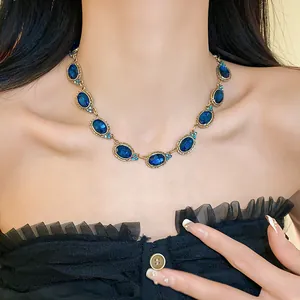 Detailed view of vintage royal blue oval gemstone necklace with elegant gold setting on model