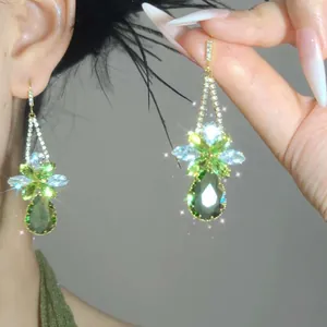 Detailed view of ethnic style emerald green teardrop tassel earrings with sparkling rhinestones