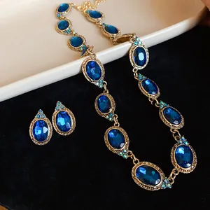 Elegant vintage palace style jewelry set featuring oval blue crystals in gold-tone metal