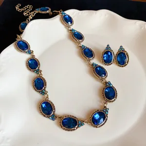 Close-up detail of vintage style jewelry set with oval blue gemstones