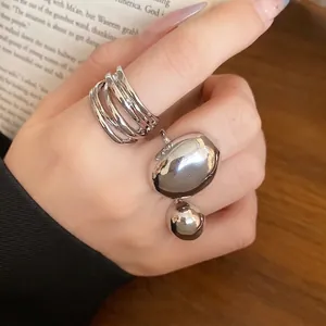 Minimalist silver-toned metal ring set with multi-layer and oval geometric designs.