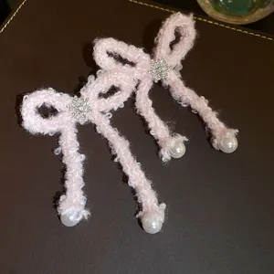 Detailed macro view of pink fuzzy bow hair clips with snowflake crystals and elegant pearls