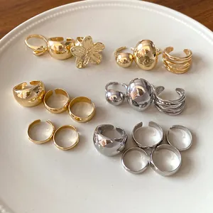 Detailed view of various minimalist metallic open rings in gold and silver finishes.