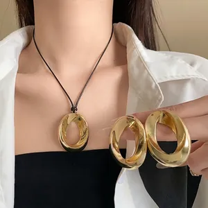 Minimalist gold twisted oval pendant necklace and chunky matching statement earrings