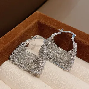 Dettaglio di eleganti orecchini a cerchio in argento con nappe e zirconi in confezione.