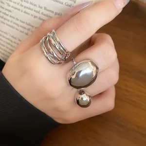 Detailed macro view showing a minimalist smooth silver metallic open ring set on hand