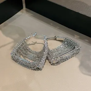 Dettaglio elegante di orecchini a cerchio con nappe in argento e pietre di zircone bianco