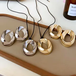 Detail view of minimalist gold and silver twisted circular necklaces on display tray