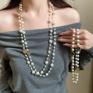 Detailed view of French vintage double-layer pearl necklace with rose charms on model