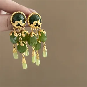 Detailed shot of vintage gold-tone earrings with elegant green gemstone tassel beads