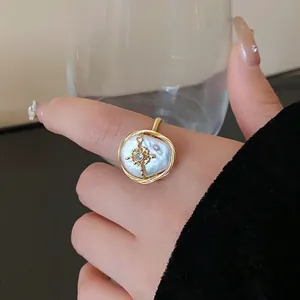 Detail view of a baroque pearl ring with gold-plated wire and zircon accent.