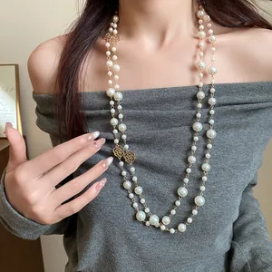 Elegant detail of a French vintage double-layer pearl necklace with golden rose charms.