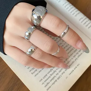 Elegant detail of a minimalist silver-finish five-piece ring set worn on a hand