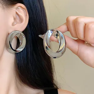 Detailed close-up view of silver minimalist chunky oval twisted hoop earrings for women