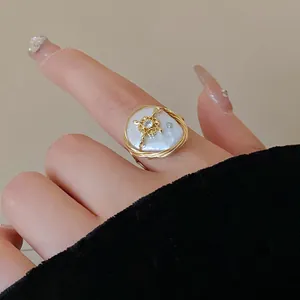 Close-up of irregular baroque pearl ring with hand-wrapped gold wire and zircon detail
