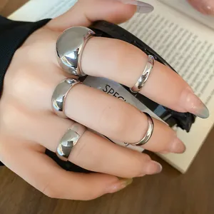 Detail view of 5-piece minimalist silver metal ring set on hand