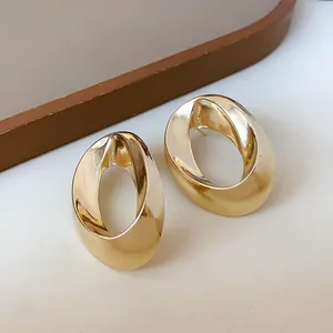 Detailed view of elegant gold-toned twisted oval stud earrings with a glossy finish