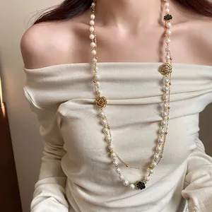 Detail view of a vintage French-style double-layered pearl and camellia flower necklace.
