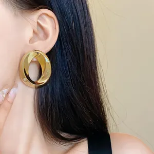 Minimalist European style large golden twisted oval earring close-up detail on model